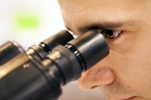 Young man looking through microscope